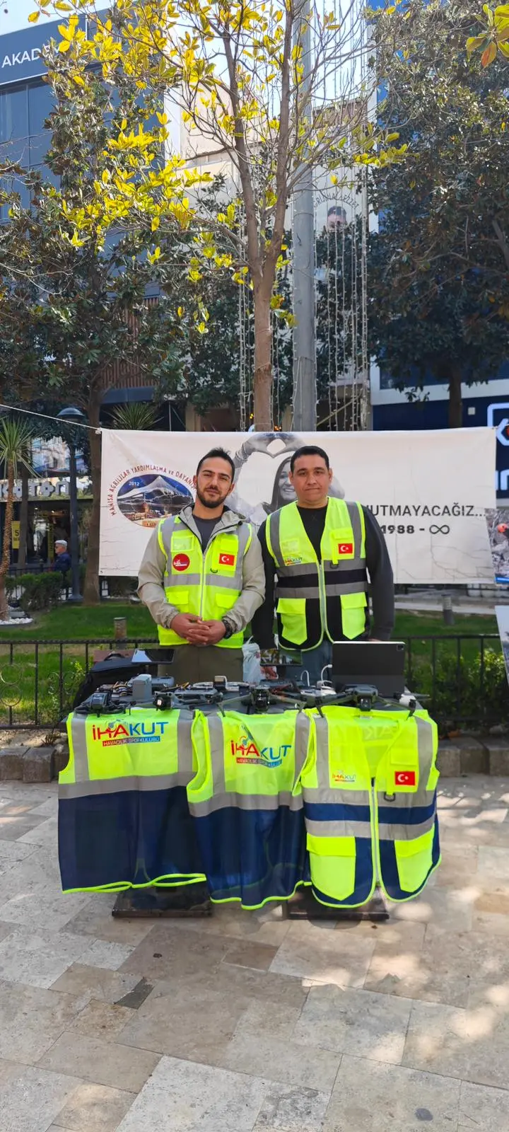 İHAKUT yeleği giymiş iki gönüllü, drone'ların dizildiği tanıtım standında